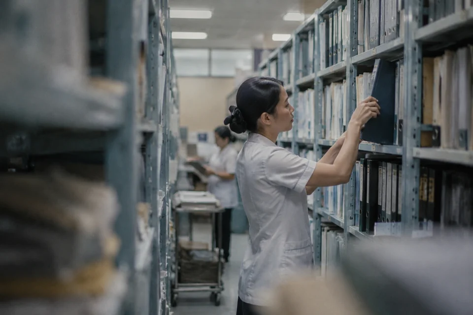A staff member finding a binder in a hospital administrative records room