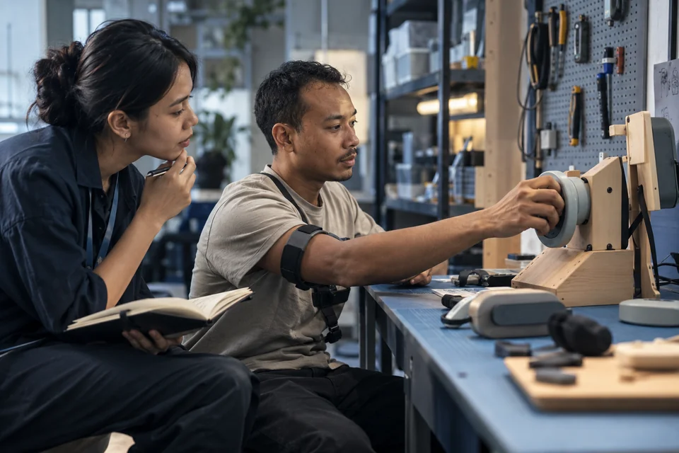 A researcher observing a participant testing a prototype